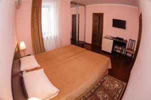 a hotel room with a bed, desk and a lamp at Guest House BoNaMi in Anapa