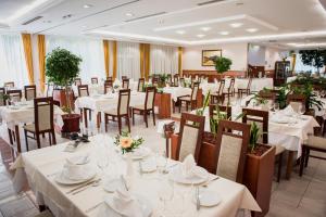 ein Festsaal mit weißen Tischen und Stühlen in der Unterkunft Garden Hotel Wellness és Konferencia in Szolnok