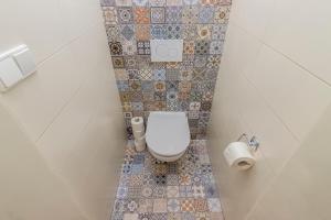 uma pequena casa de banho com WC e azulejos na parede em City centre Apartment Prague by Michal&Friends em Praga