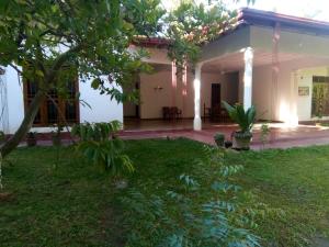 a house with a green lawn in front of it at Siyapath Holiday Resort in Polonnaruwa