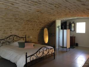 - une chambre avec un lit et un mur en pierre dans l'établissement Le Domaine des Ramonets, à Cahors