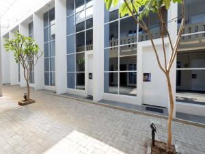 an empty courtyard in a building with two trees at RedDoorz Plus near Paragon Mall Semarang in Semarang