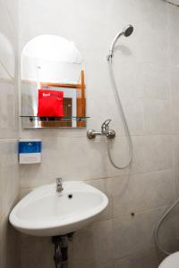 a bathroom with a sink and a shower with a mirror at RedDoorz Near Kota Lama Semarang in Semarang