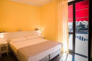 a bedroom with a bed and a large window at Hotel Marisa in Albenga