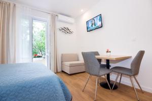 um quarto com uma cama, uma mesa e cadeiras em Lugo Apartments em Split