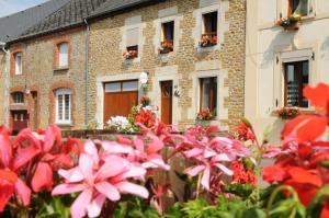 un grupo de flores frente a un edificio en Chambres d'hôtes L'Hirondelle en Girondelle