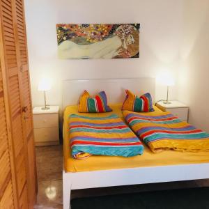 um quarto com 2 camas com almofadas coloridas e um quadro em Aquamar em Patalavaca