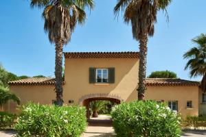 a house with palm trees in front of it at Les Maisons Du Sud in Saint-Tropez