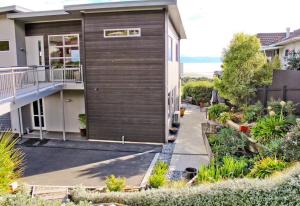 a house with a wooden facade and a walkway at Apartment on Stansell in Nelson