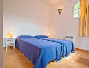 two beds in a room with blue blankets at Résidence Les Hameaux de Santa Giulia in Porto-Vecchio