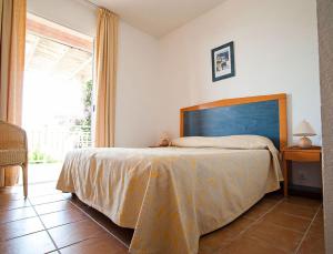 a bedroom with a bed in a room with a window at Résidence Les Hameaux de Santa Giulia in Porto-Vecchio