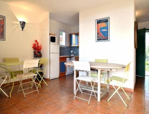 a kitchen and dining room with a table and chairs at Résidence Les Hameaux de Santa Giulia in Porto-Vecchio