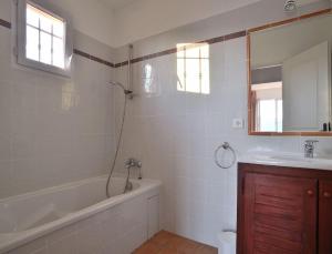 a bathroom with a bath tub and a sink at Résidence Les Hameaux de Santa Giulia in Porto-Vecchio