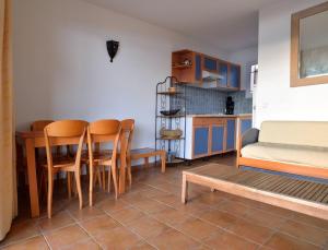 a kitchen with a table and chairs in a room at Résidence Les Hameaux de Santa Giulia in Porto-Vecchio