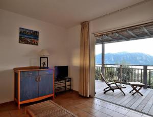 a living room with a balcony with a sliding glass door at Résidence Les Hameaux de Santa Giulia in Porto-Vecchio