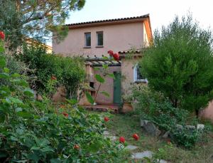a house with a garden with flowers in front of it at Résidence Les Hameaux de Santa Giulia in Porto-Vecchio