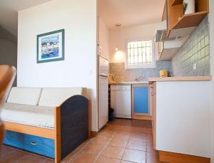 a small room with a bunk bed and a kitchen at Résidence Les Hameaux de Santa Giulia in Porto-Vecchio