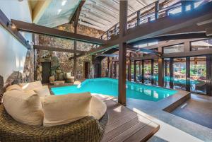 uma piscina interior com um sofá e uma cadeira numa casa em Hotel Pušų paunksnėje em Palanga