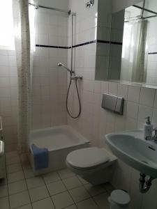 
a bathroom with a toilet, sink, and bathtub at Appartement-Hotel Rostock in Rostock
