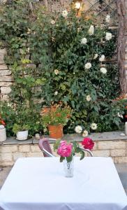 Una mesa blanca con un jarrón de flores. en Archontiko Evridikis, en Vitsa