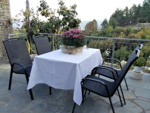 una mesa con un mantel blanco y flores en ella en Archontiko Evridikis, en Vitsa