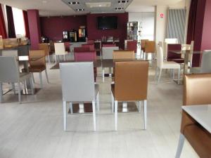 comedor con sillas blancas y mesa en Hôtel Saint-Pierre, en Vire