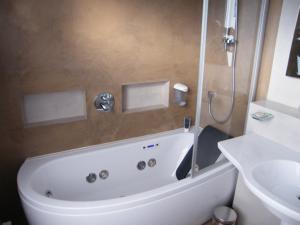 eine weiße Badewanne im Bad mit Waschbecken in der Unterkunft Hôtel Saint-Pierre in Vire