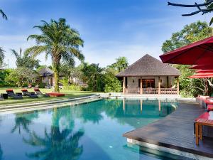 a swimming pool with a gazebo and a house at Villa The Beji in Canggu