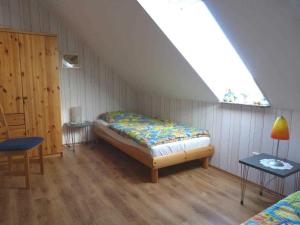 a bedroom with a bed in a attic with a window at Muus Rudolf in Rettin