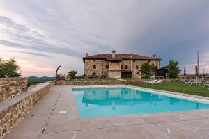a house with a swimming pool in front of a building at Agriturismo Ronchi Di Sant'Egidio in Manzano