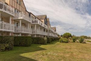 una fila de edificios de apartamentos con arbustos en un patio en Residence Port du Crouesty Cap Ocean - maeva Home, en Arzon