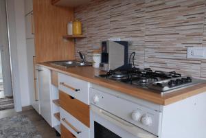 a kitchen with a stove top oven next to a sink at Villa Genna in San Vito lo Capo