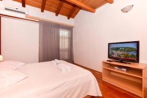 sypialnia z łóżkiem i telewizorem z płaskim ekranem w obiekcie Apartmani Mate w Makarskiej