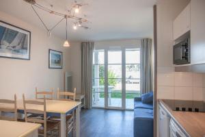 Una cocina y una sala con una mesa y un comedor. en Residence Port du Crouesty Cap Ocean - maeva Home, en Arzon