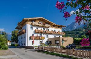 ein großes weißes Gebäude mit Balkon auf einer Straße in der Unterkunft Der Dolomitenhof - Tristach in Lienz