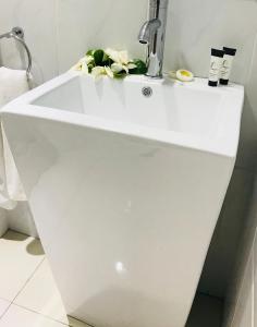 een badkamer met een wit bad en een wastafel bij Samoana Boutique Hotel in Apia