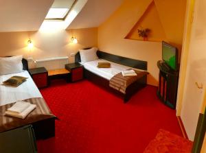 ラダウツィにあるPension Hotel Fastのベッド2台、薄型テレビが備わる客室です。
