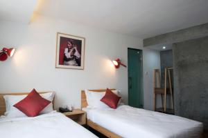 ein Schlafzimmer mit 2 Betten und einem Bild an der Wand in der Unterkunft Potala Guest House in Kathmandu