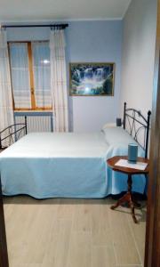 1 dormitorio con 1 cama grande y 1 mesa en AGRITURISMO NIZUR'IN, en Roccaverano