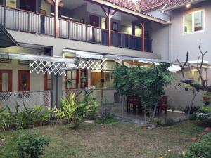 an external view of a house with a patio at De Riau Guesthouse in Bandung