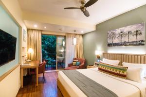 坎多林Novotel Goa Resort & Spa Candolim的配有床和书桌的酒店房间 更多37张照片