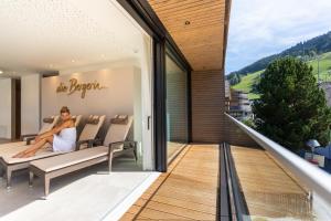 una mujer sentada en el balcón de una casa en ''die Bergerin'' | Appartements Schladming en Schladming