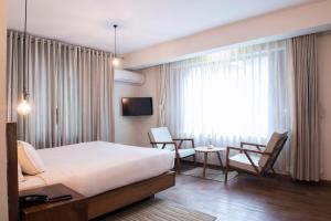 una camera da letto con un letto, due sedie e una finestra di Potala Guest House a Kathmandu