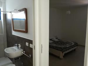 bagno con lavandino e letto con specchio di Mediterranea Guesthouse B&B a Portopalo Altre 26 foto
