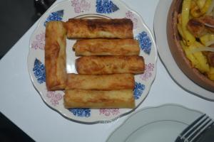 three fish sticks on a plate with a bowl of food at hotel niks in Makhinjauri