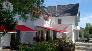 a white building with red awnings on it at Hotel Boskamp in Bergisch Gladbach