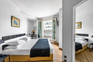 um quarto com 2 camas e uma janela em Etoile Park Hotel em Paris