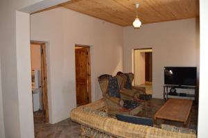 a living room with two couches and a tv at Esmarline Lodge in Brits