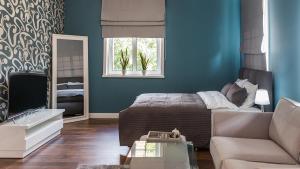 ein Schlafzimmer mit einem Bett, einem Sofa und einem Spiegel in der Unterkunft Apart-Henryk in Nysa
