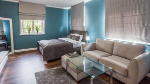 uma sala de estar com um sofá e uma cama em Apart-Henryk em Nysa